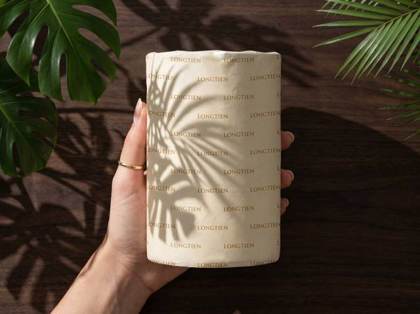 Hands holding the textured art-paper wrapped bottle